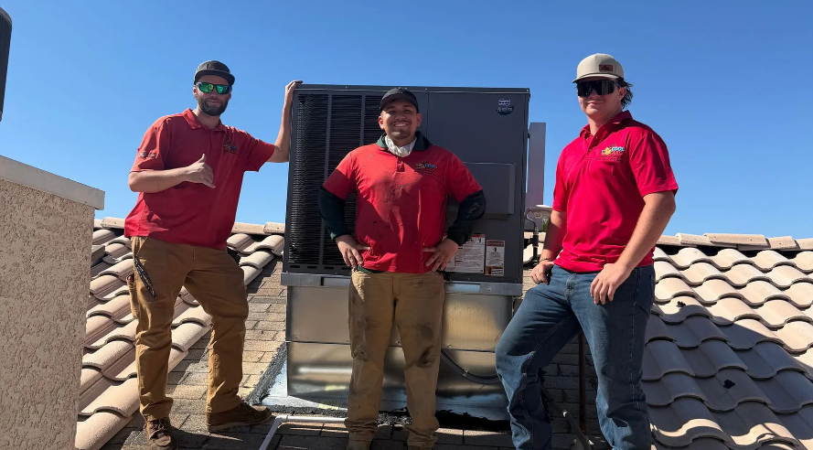 Cool Camel HVAC technicians standing on a rooftop next to a new unit